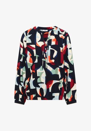 Halenka s dlouhými rukávy s elastickými manžetami, kulatým výstřihem se zavazováním vpředu a vícebarevným abstraktním geometrickým vzorem v námořnické modři, červené, bílé a zelené.