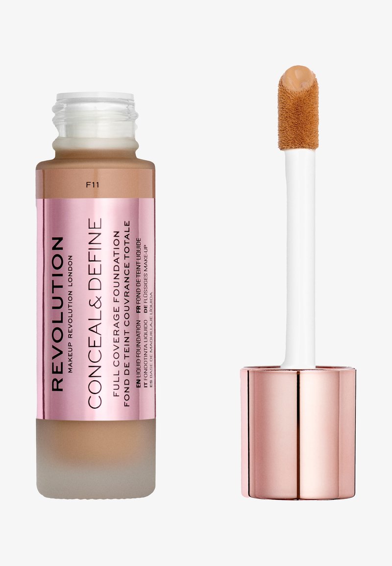 Fondotinta a copertura totale in una bottiglia di vetro con etichetta rosa. Presenta una base satinata e un applicatore a spugna con prodotto color beige.
