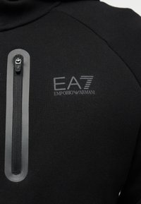 Μαύρο φούτερ με φερμουάρ, με λεία υφή, που διαθέτει κατακόρυφο φερμουάρ και γκρι λογότυπο «EA7 EMPORIO ARMANI» στο στήθος.