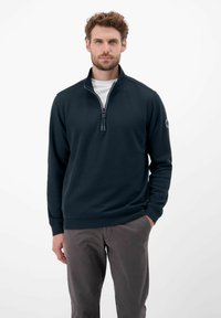 Granatowa, półzipsowa bluza wykonana z miękkiego materiału, z prążkowanymi mankietami i dolnym wykończeniem, z centralnym zamkiem błyskawicznym oraz naszywką z logo na lewym rękawie.