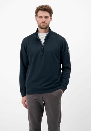 Navy half-zip pullover made of soft material with ribbed cuffs and hem, featuring a central zipper and a logo patch on the left sleeve.