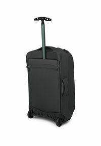 Valigia nera con manico verde retrattile, texture liscia, tasca frontale con zip, ampio compartimento principale e ruote resistenti.