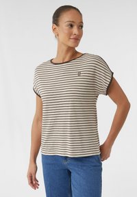 Gestreiftes T-Shirt mit kurzen Ärmeln in Creme mit dunkelbraunen Streifen. Rundhalsausschnitt, lockere Passform, kleines Logo auf der Brust, weicher Stoff.