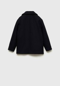 Svart ullrock med klassisk krage, långa ärmar och rak design. Ingen synlig metall eller mönster, slät textur.