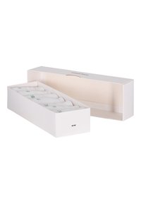 Caja rectangular blanca con tapa, que contiene varios elementos enrollados, textura visible en los rollos y acentos verdes impresos.