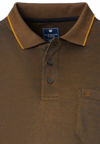 Braunes Poloshirt aus strukturiertem Stoff, mit kontrastierenden gelben Details am Kragen und drei Knopfverschlüssen. Verfügt über eine kleine Brusttasche.