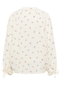 Blusa larga di colore crema con motivo paisley in rosso e blu, polsini elastici con lacci e scollo rotondo.