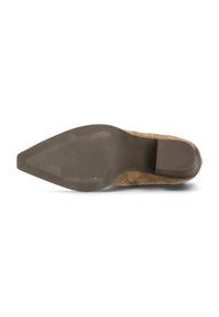 Zapato de tacón para mujer en ante marrón con punta afilada y suela de goma texturizada. Los detalles laterales y el tacón apilado complementan el diseño.