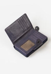 Portafoglio in pelle blu navy con chiusura zip, più scomparti per carte, una finestra trasparente per l'ID e una texture liscia. L'interno è realizzato in tessuto chiaro.