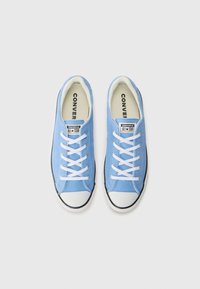 Lichtblauwe canvas sneakers met witte veters, witte rubberen neuskap en een zwarte accent langs de zool. Voorzien van "Converse All Star" branding.