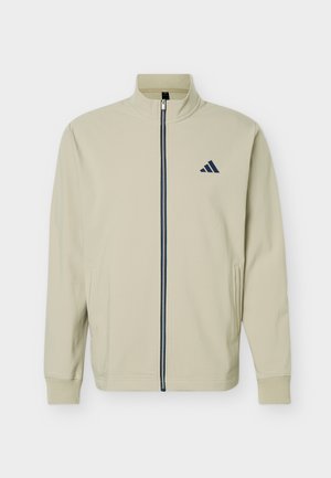 Beige krāsas džemperis ar melnu rāvējslēdzēju un nelielu melnu logotipu kreisajā krūtī, ar ribveida aprocēm un sānu kabatām.