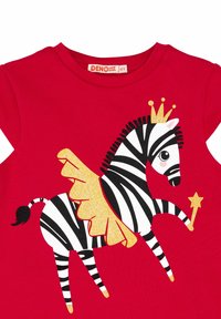 Rotes T-Shirt mit einer schwarz-weißen Zebra-Illustration, die goldene Akzente, eine Krone und Flügel aufweist, im verspielten Design gestaltet.