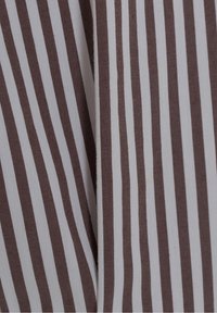 Tissu rayé vertical marron et blanc avec un pli visible créant une légère ombre au centre.