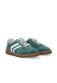 Grüne Wildledersneaker mit weißen Streifen, Gummisohlen und Schnürverschluss. Die strukturierte Oberfläche und die kontrastierenden Nähte heben das Aussehen hervor.