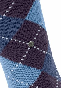 Calzino a motivo argyle nelle tonalità di blu e maroon, con un piccolo tag metallico con marchio vicino alla parte superiore, che mostra un design in maglia texturizzata.