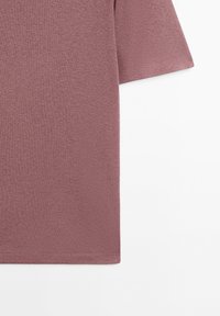 Short-sleeve t-shirt in mauve fabric with a smooth texture, featuring a crew neckline and straight hem. No visible patterns or embellishments.