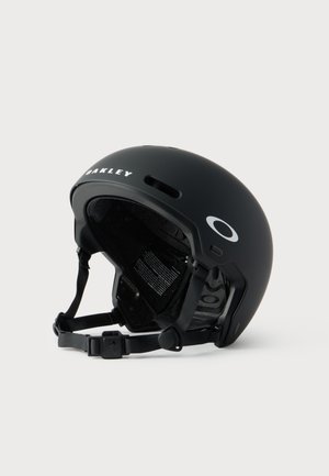 Матово черен спортен каска Oakley с регулируема каишка за брадичка и отвори за вентилация, предназначена за защита на главата по време на дейности.