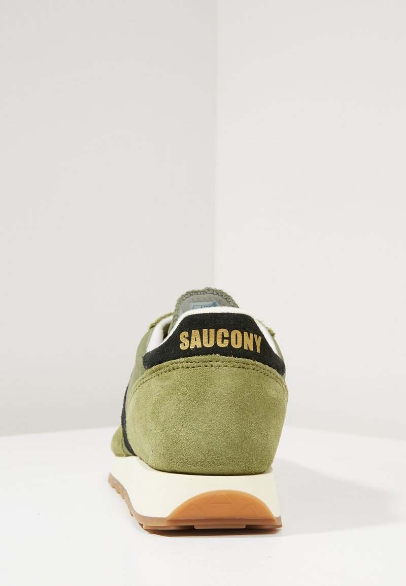 Groene suède sneaker met zwarte accenten, textuur op de hiel en gouden branding. Beschikt over een gevoerde zool en een stevige rubberen loopzool voor grip.