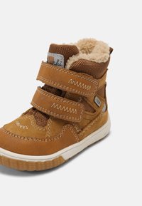 Botte d'hiver pour enfants marron avec deux sangles en Velcro, doublure en polaire, tige texturée et semelle blanche sur un fond uni.