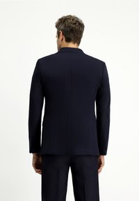 Granatowa marynarka o dopasowanym kroju, z pojedynczym rozcięciem z tyłu i mankietami zapinanymi na guziki. Wykonana z fakturowanej tkaniny, zapewniającej dopasowany wygląd.