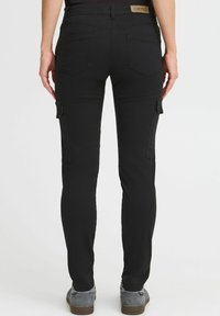 Zwarte cargobroek met een slim-fit, voorzien van twee zijzakken, achterzakken en een merkband aan de taille. Gemaakt van stretchstof.