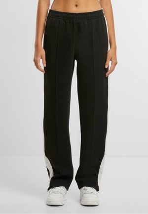 Svarta sweatpants med en avslappnad passform, med kontrasterande sidopaneler, elastisk midja och mjuk tygtextur.