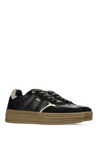 Une paire de sneakers noires basse avec des accents beiges, un détail de talon en imprimé léopard, des lacets à motifs et des semelles épaisses en caoutchouc marron.