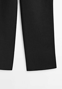 Partie inférieure d’un pantalon noir droit avec des ourlets nets sur fond blanc.
