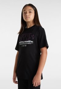 Sort bomulds t-shirt med rund hals, korte ærmer og et grafisk print med "VANS Off The Wall Co." i lilla og hvid.