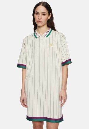 Korte mouwen polo jurk in crème met groene en paarse verticale strepen, voorzien van een knoopsluiting en een logopatch op de borst.