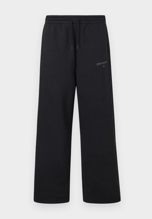 Černé tepláky New Balance s elastickým pasem, stahovací šňůrkou a malým logem na horní levé stehně.