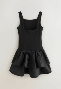 Robe noire sans manches avec encolure carrée et jupe à volants superposés, présentée à plat sur un fond clair.