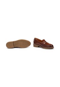 Mocasines de cuero marrón con parte superior texturizada, correa decorativa y tacón bajo. La suela presenta un diseño de banda para mayor agarre.