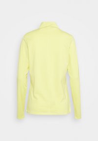 Långärmad, bakvy av en ljusgul, lätt skjorta med krage och slät yta, med ett centrerat sömdesign.