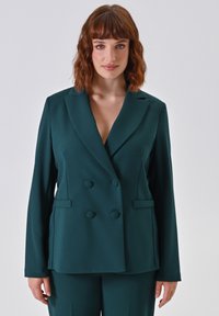 Teal dubbelzijdig blazer met een notched collar, twee vo pockets en een gladde stoftextuur. Voorzien van grote ronde knopen.