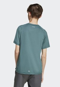 Tyrkysová tričko s krátkym rukávom a textúrovaným povrchom, okrúhlym výstrihom a šikmými švami. Obsahuje štítok pri golieri.