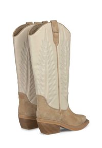 Botas de cowboy de cuero beige con una sección inferior de ante, que presentan patrones de hojas bordados y un tacón apilado.
