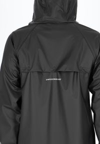 Black waterproof jacket with a hood, featuring a rear flap and two snap buttons, and "SWEDEMOUNT" logo on the upper back.