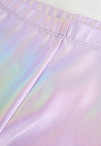 Iridescent lavanda tajice s glatkom teksturom, koja ima rastezljivi pojas i suptilne detalje u šivanju.