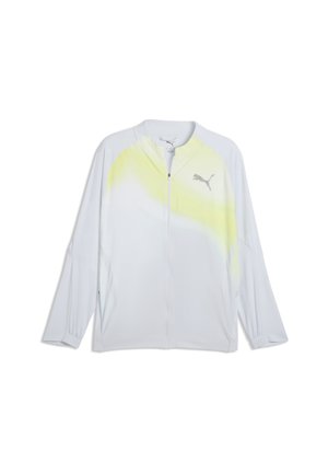 Biała kurtka marki Puma zapinana na zamek, z subtelnym żółtym gradientem na ramionach i logo Puma po lewej stronie klatki piersiowej, długie rękawy i elastyczne mankiety.