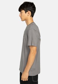 Grijze kortgemouwen t-shirt met een ronde halslijn, voorzien van een klein logo op de borst en een relaxed fit. De stof lijkt zacht en licht van gewicht.