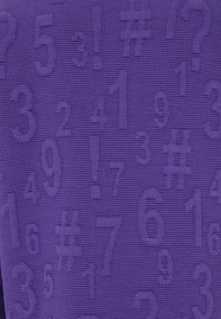 Lila strukturierter Stoff mit erhabenen Zahlen, Symbolen und Rautenzeichen in verschiedenen Größen, die ein Muster über die Oberfläche bilden.