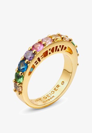 Gouden ring met een rij van meerkleurige, ovale edelstenen en uitgesneden tekst "BE KIND" aan de binnenkant. Gladde afwerking.
