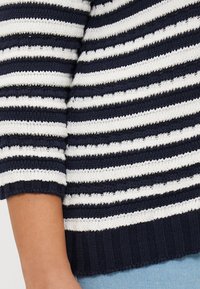 Sweater featuring navy and white horizontal stripes, knit texture, ribbed cuffs and hem, with a slightly loose fit and short sleeves.