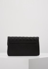 Mustan tikkauksen nahkainen clutch-laukku, jossa on litteä, suorakulmainen muoto ja sileä pinta. Magneettinen napitus ja siistiä ompelua.