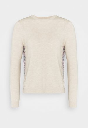 Kremowy sweter z długim rękawem, okrągłym dekoltem i bocznymi panelami z tkaniny w kwiatowy wzór.