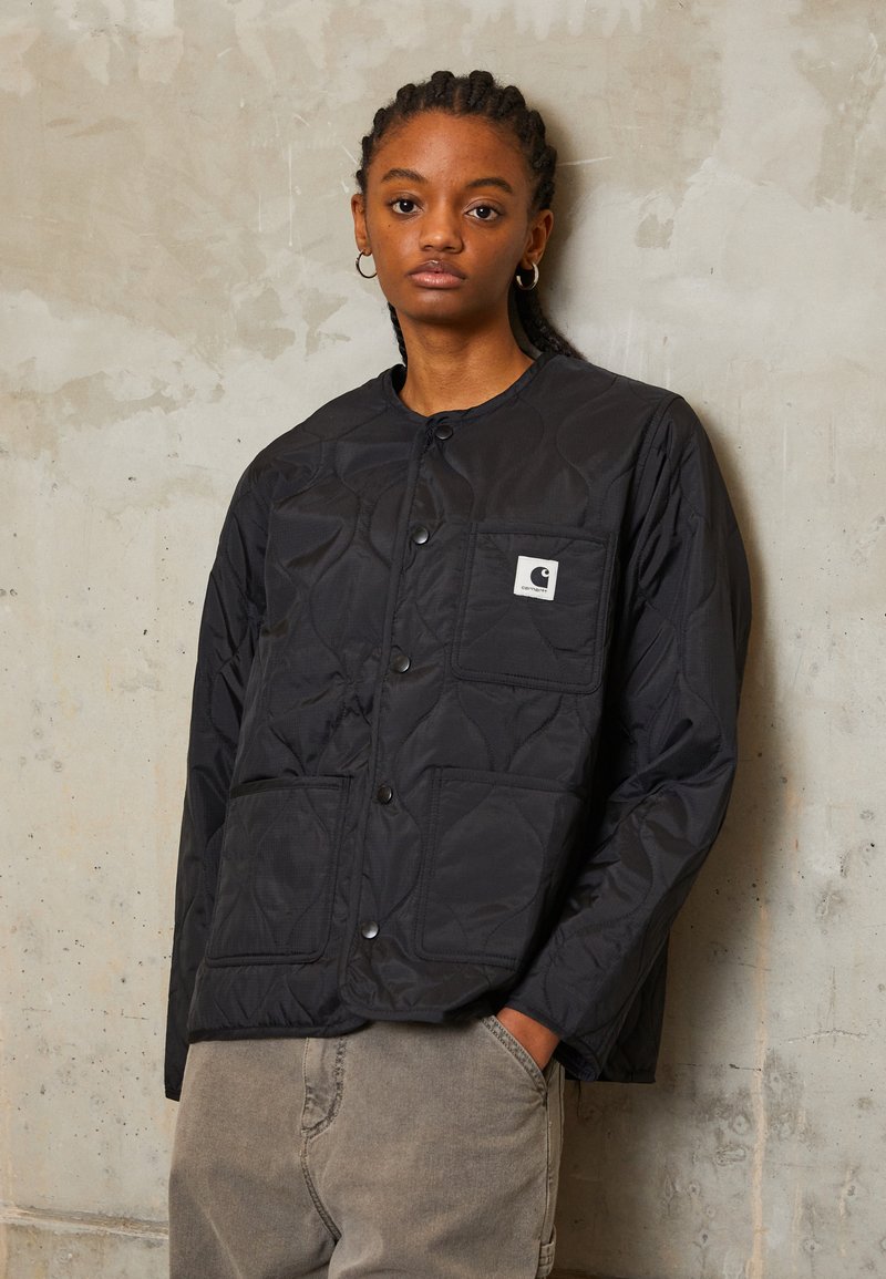 Zwarte gewatteerde jas met drukknoopsluiting en een patch pocket. De stof heeft een soepele textuur, met een lichtgewicht ontwerp en een oversized pasvorm.
