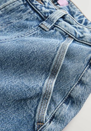 Jeans din denim albastru deschis cu un design clasic cu cinci buzunare, detalii de croi vizibile și o textură ușor decolorată.
