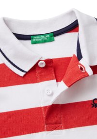 Polo tričko s červenými a bílými pruhy, námořnický límec, dvě bílé knoflíky a logo. Nálepka uvádí "United Colors of Benetton." Texturovaná látka.