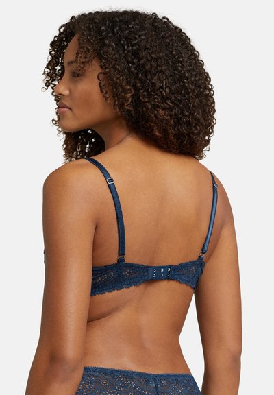 Marinblå spets-bh med justerbara axelband och hake-och-ögonstängning bak. Har intrikata blommönster och mjukt texturerat tyg.